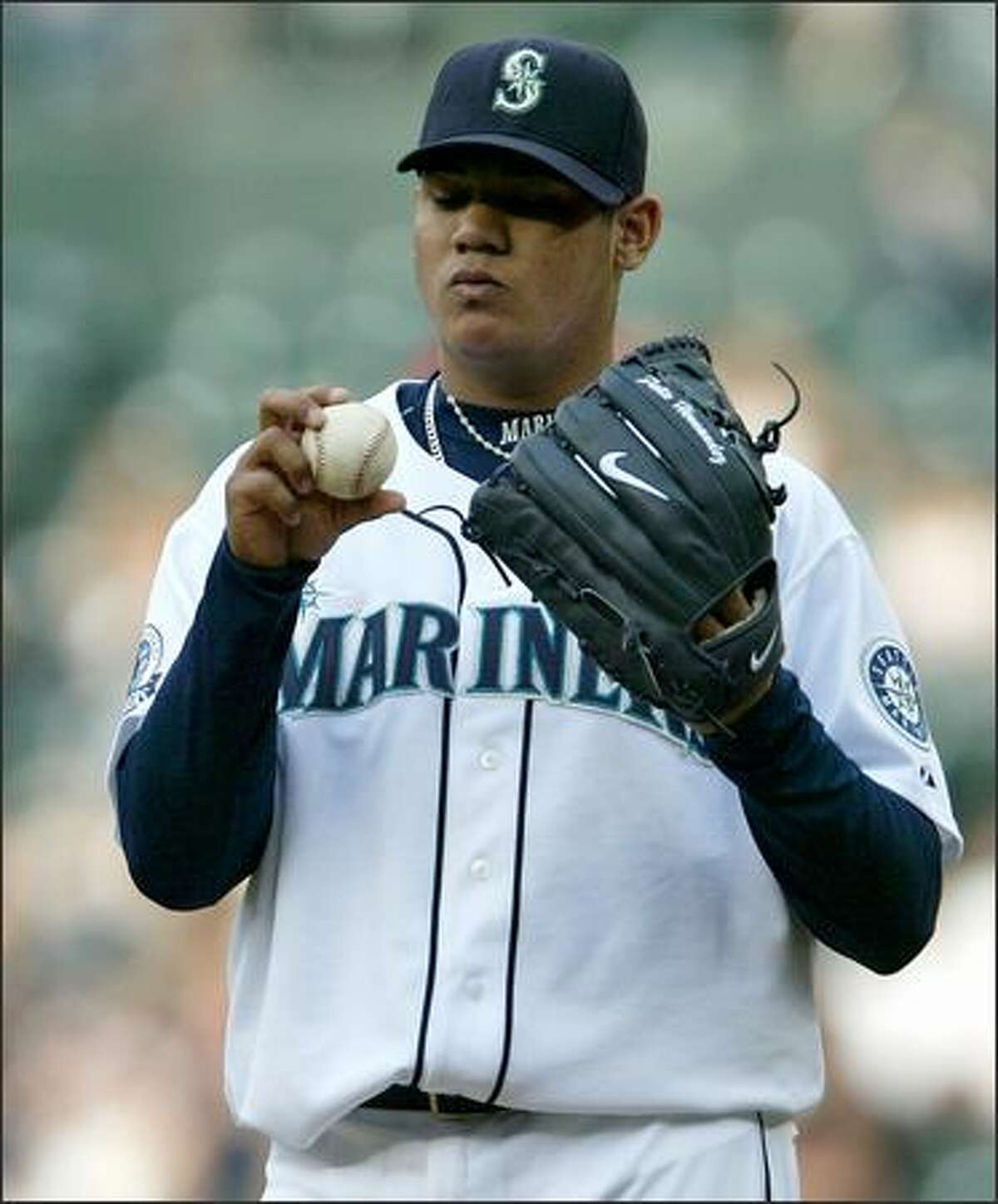 Seattle Mariners Felix Hernandez inspects the ball as he works through a rough start against the Boston Red Sox during first inning action at Safeco Field in Seattle Tuesday.