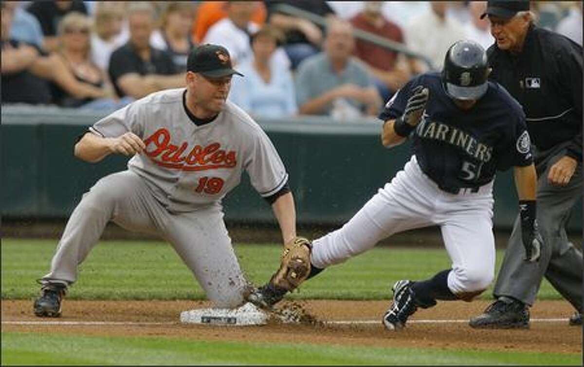 After hitting a double in the first inning Ichiro Suzuki #51 beats the tag of Aubrey Huff #19 as he steels 3rd base setting himself up to score as the Mariners go up against the Orioles Monday in the opener of a three game home stand at Safeco Field.