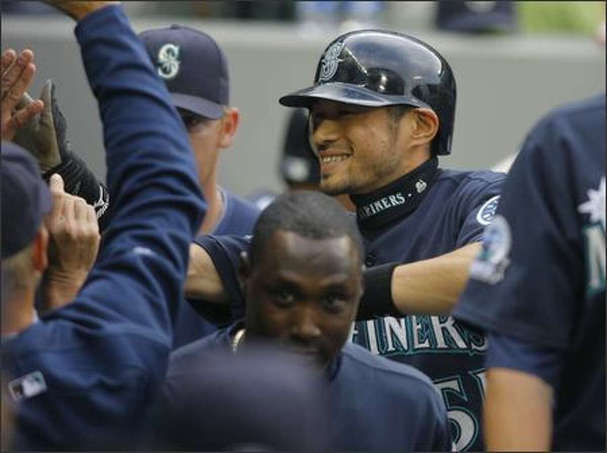Seattle’s Ichiro Suzuki is congratulated after scoring in the first inning against the Orioles Monday in the opener of a three game home stand at Safeco Field.