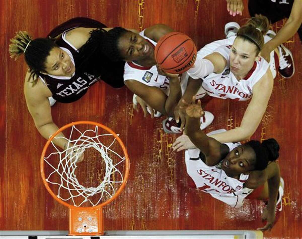 Stanford players Kayla Pedersen, top right, Chiney Ogwumike, bottom right, Nnemkadi Ogwumike, center, and Texas A&M's Danielle Adams, left, battle for a rebound in the first half of a women's NCAA Final Four semifinal college basketball game in Indianapolis, Sunday, April 3, 2011.