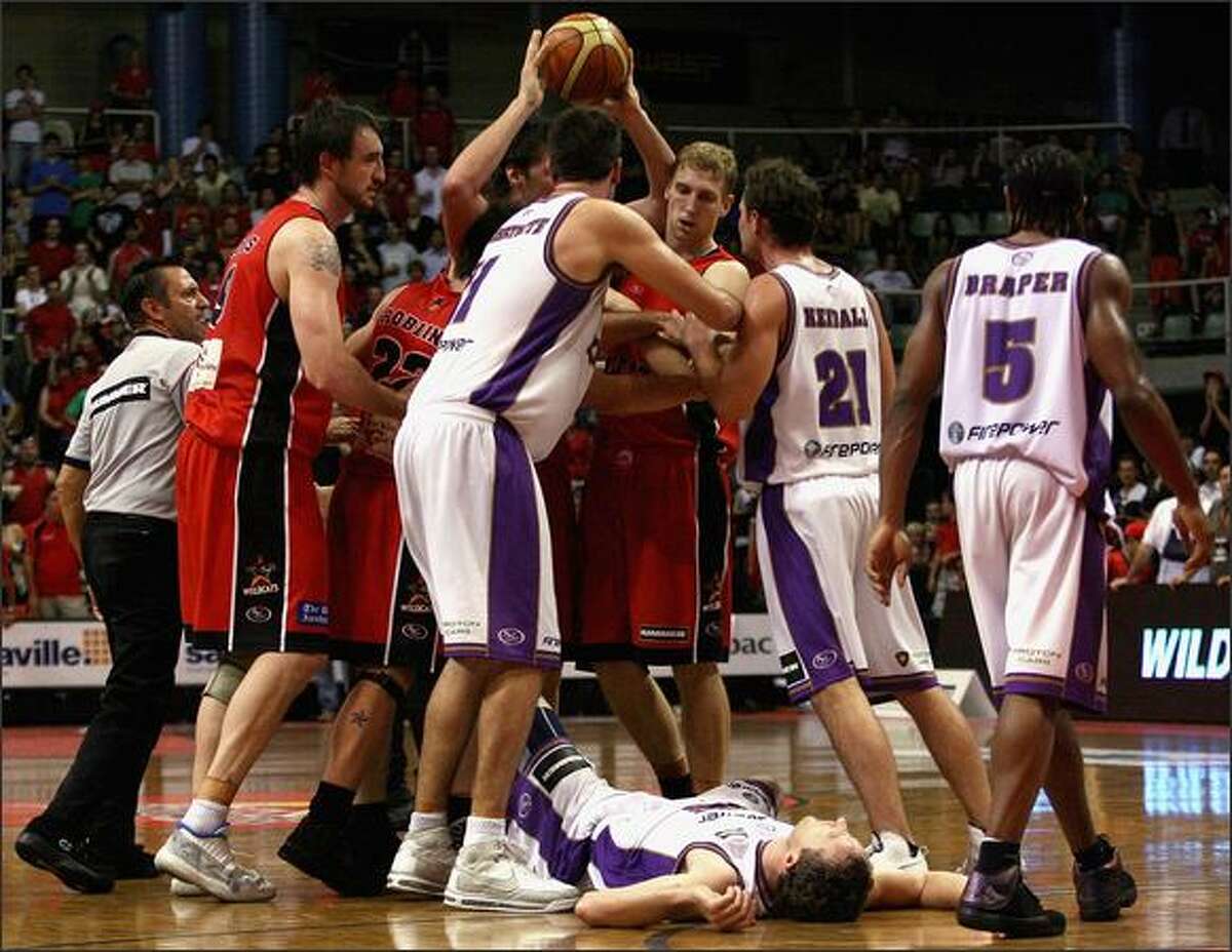 Ian Crosswhite and Luke Kendall of the Kings push away Shawn Redhage after Glen Saville from the Kings was struck by the elbow of Alex Loughton of the Hawks during game two of the NBL semi final series between the Perth Wildcats and the Sydney Kings at Challenge Stadium in Perth, Australia. Photo by Paul Kane/Getty Images