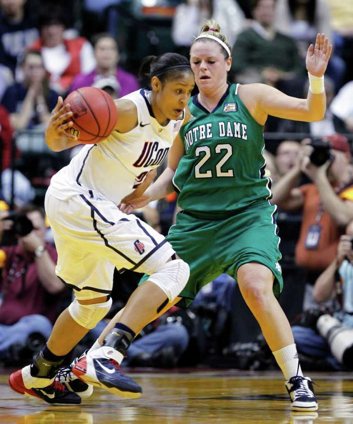 Connecticut's Maya Moore, left, drives on Notre Dame's Brittany Mallory (22) in the first half of a women's NCAA Final Four semifinal college basketball game in Indianapolis, Sunday, April 3, 2011. (AP Photo/Michael Conroy)