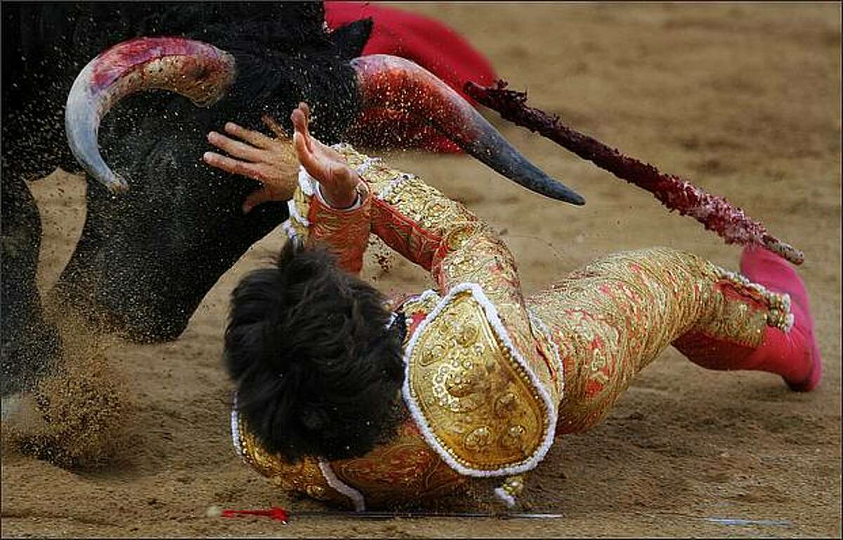 French matador Sebastian Castella is gored by a Fuente Ymbro's ranch bull during a bullfight in Pamplona, northern Spain, at the San Fermin festivities on The fiestas 'Los San Fermines' held since 1591, which attract tens of thousands of foreign visitors each year for nine days of revelry, morning bull-runs and afternoon bullfights. The San Fermin festival gained worldwide fame in Ernest Hemingway's 1926 novel 'The Sun Also Rises.' (AP Photo/Daniel Ochoa de Olza)