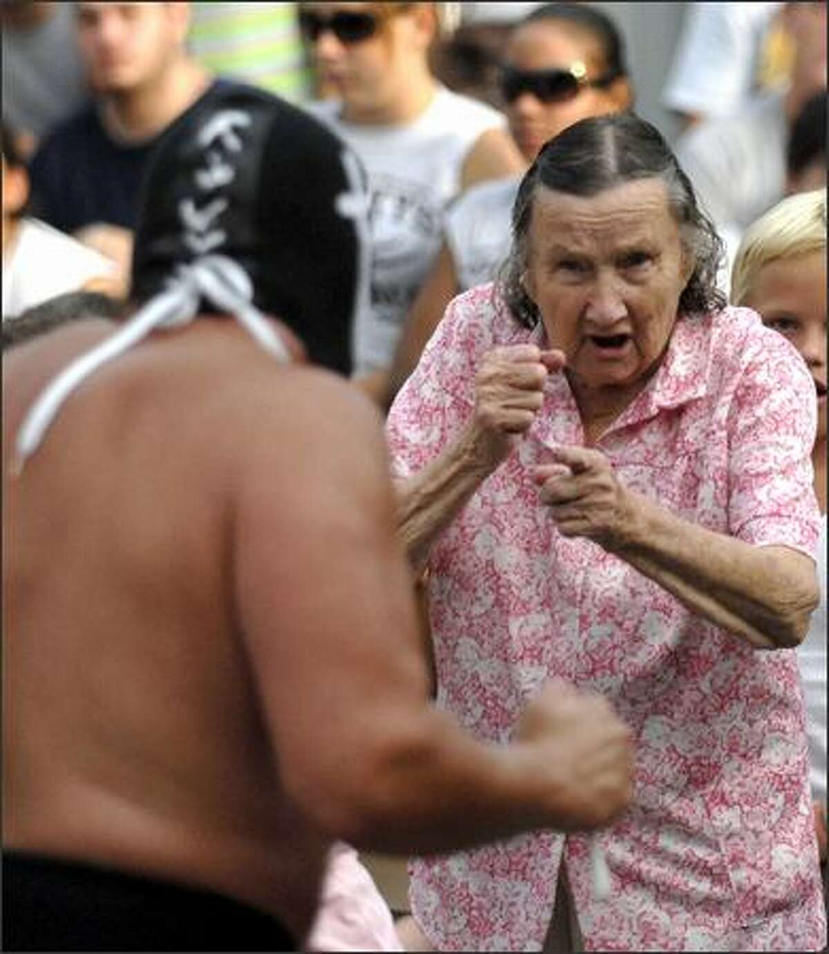 Dorothy Brown, 90, right, prepares to fight the professional wrestler called the "Sheek of Arabi" Wednesday, Aug. 8, 2007, as she gets carried away by the professional wrestling action at the Champaign County Fair in Urbana, Ohio. Photo/Springfield News-Sun, Bill Lackey
