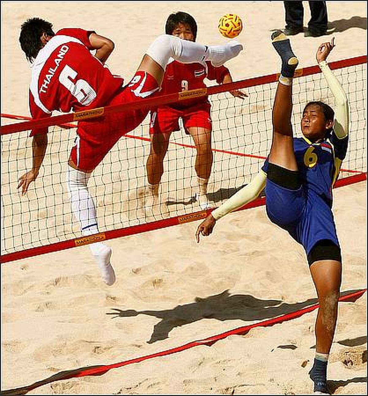 Tidawan Daosakul of Thailand and Lena of Indonesia contest at the net for a ball during the Women's Beach Sepaktakraw gold medal match between Thailand and Indonesia on day four of the 2008 Asian Beach Games at Sanur Beach in Bali, Indonesia. (Photo by Quinn Rooney/Getty Images)