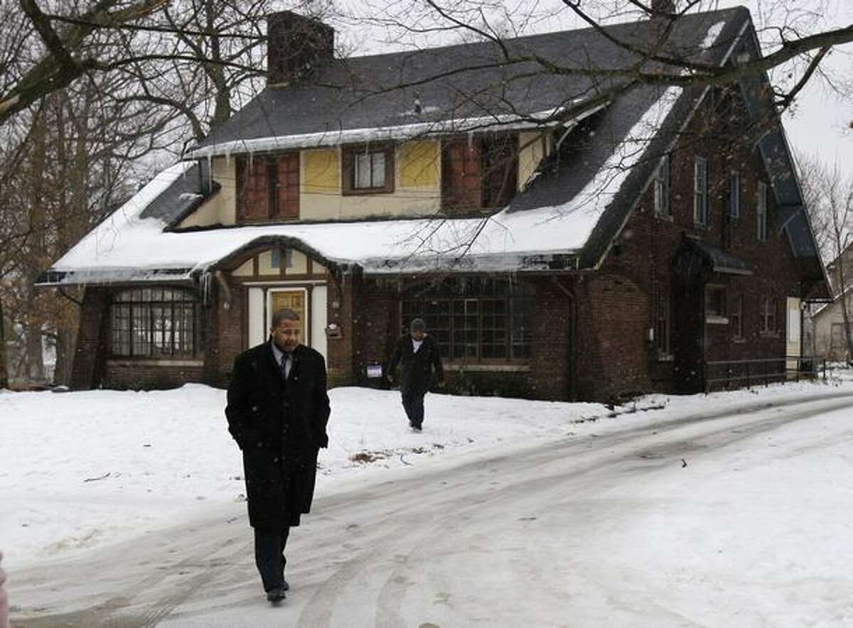 Phil Walls, brother of one of the shooting victims, leaves a house in Youngstown, Ohio Monday where one college student was killed and 11 injured early Sunday. A day after an admired college student was shot dead and 11 people were injured, the governor, college officials and friends were seeking an explanation for the violence. (AP Photo/Tony Dejak)