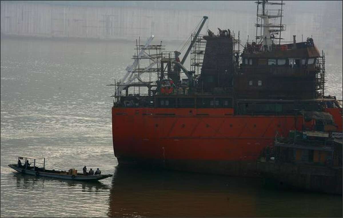 Workers check a ship being built at a Chongqing Changhang Dongfeng Vessel Industry Company dock on February 12, 2009 in Chongqing, China. China's State Council has sanctioned a stimulus package for the ship building industry at an executive meeting chaired by Chinese PM Wen Jiabao. The meeting confirmed an increase in credit support for ship buyers and maintain the existing financial support policies for oceangoing vessels until 2012, state media said.