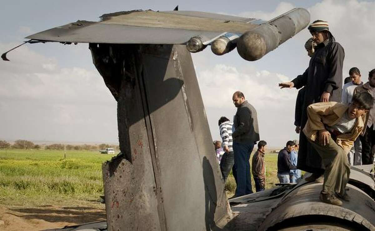 Libyans inspect the wreckage of a U.S. F-15 fighter jet after it crashed in an open field in the village of Bu Mariem, east of Benghazi, eastern Libya, Tuesday with both crew ejecting safely. The U.S. Africa Command said both crew members were safe after what was believed to be a mechanical failure of the Air Force F-15. The aircraft, based out of Royal Air Force Lakenheath, England, was flying out of Italy's Aviano Air Base in support of Operation Odyssey Dawn.(AP Photo/Anja Niedringhaus)
