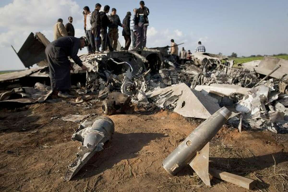 Libyans inspect the wreckage of a U.S. F-15 fighter jet after it crashed in an open field in the village of Bu Mariem, east of Benghazi, eastern Libya, on Tuesday with both crew ejecting safely. The U.S. Africa Command said both crew members were safe after what was believed to be a mechanical failure of the Air Force F-15. The aircraft, based out of Royal Air Force Lakenheath, England, was flying out of Italy's Aviano Air Base in support of Operation Odyssey Dawn.(AP Photo/Anja Niedringhaus)