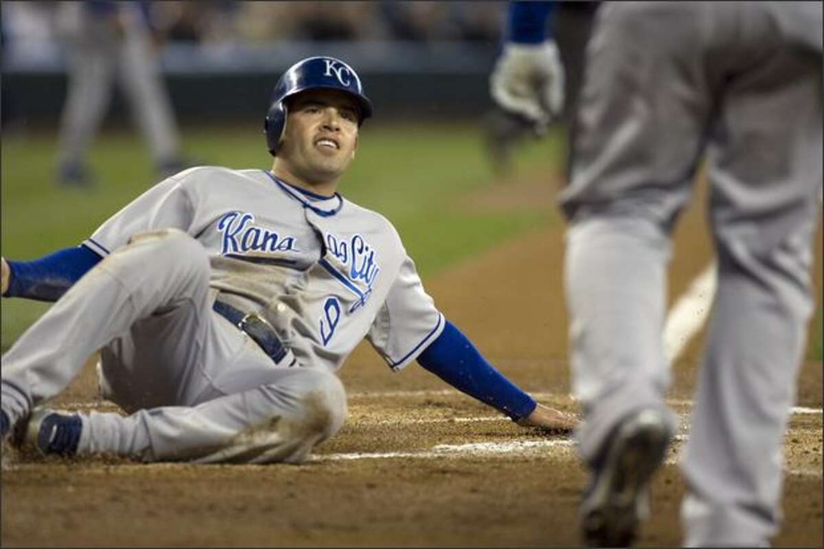Kansas City's David DeJesus looks up to the homeplate umpire as he scores his team's first run in the first inning.