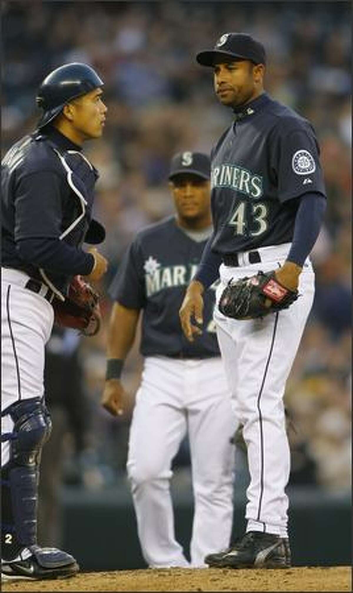Mariner’s pitcher Miguel Batista talks to catcher Kenji Johjima just before leaving the game with an injury in the second inning against the Oakland A’s.