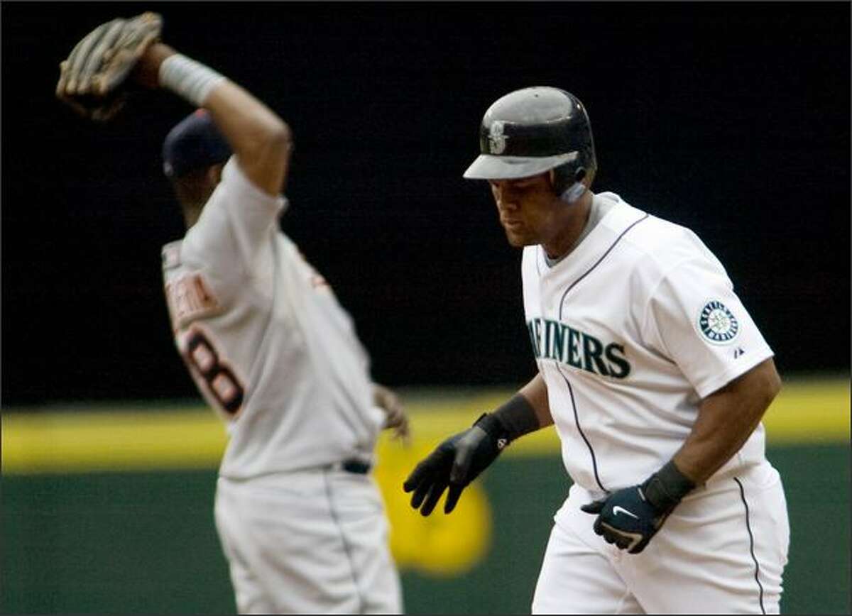 Seattle Mariners' Adrian Beltre, right, runs past Detroit Tigers shortstop Egar Renteria after hitting a solo home run to right field in the second inning.