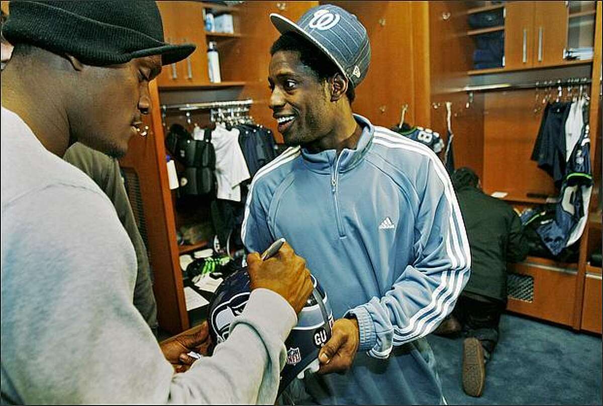 Seattle Seahawks wide receiver Deion Branch (right) had teammates, including Courtney Taylor pictured here, sign his helmet at the Virginia Mason Athletic Center.