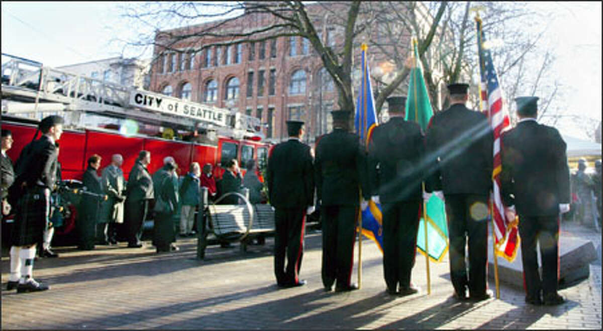 At the Fallen Firefighter Memorial in Occidental Park, an honor guard stands at attention during a ceremony to remember four Seattle firefighters who died in the Pang warehouse fire 10 years ago.