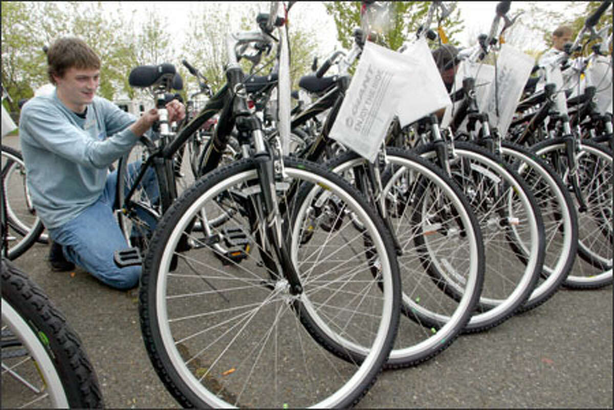 As part of National Bike to Work Month, 50 people won free bikes based on a short essay they wrote about how they would incorporate a bike into their mass-transit commute. The League of American Bicyclists, the Montlake Bike Shop and Shimano donated the bikes, which were given away at Gas Works Park. Gary Tegantvoort, a service manager for Montlake Bicycle Shop, inspects the bikes before the giveaway.