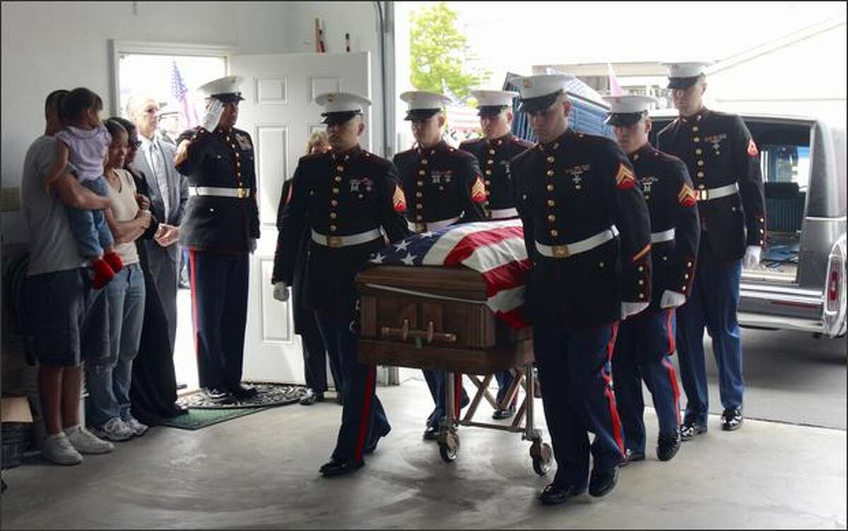 The flag-draped casket of Marine Sgt. Michael T. Washington arrives at Klontz Funeral Home in Auburn, Wash. after arriving on a flight at McChord Air force Base. In attendance are his saluting father Michael W. Washington, mother Grace Washington, in black, sister Aja Collins, her husband Eric Collins and her daughter, Jada Collins, 2. Washington is the first Marine with ties to Washington state among the 23 locally connected members of the armed forces who have died in Afghanistan. His father, Michael W. Washington, a Seattle fire fighter and Marine who also once served in Afghanistan, escorted the casket and greeted other family members at the funeral home.