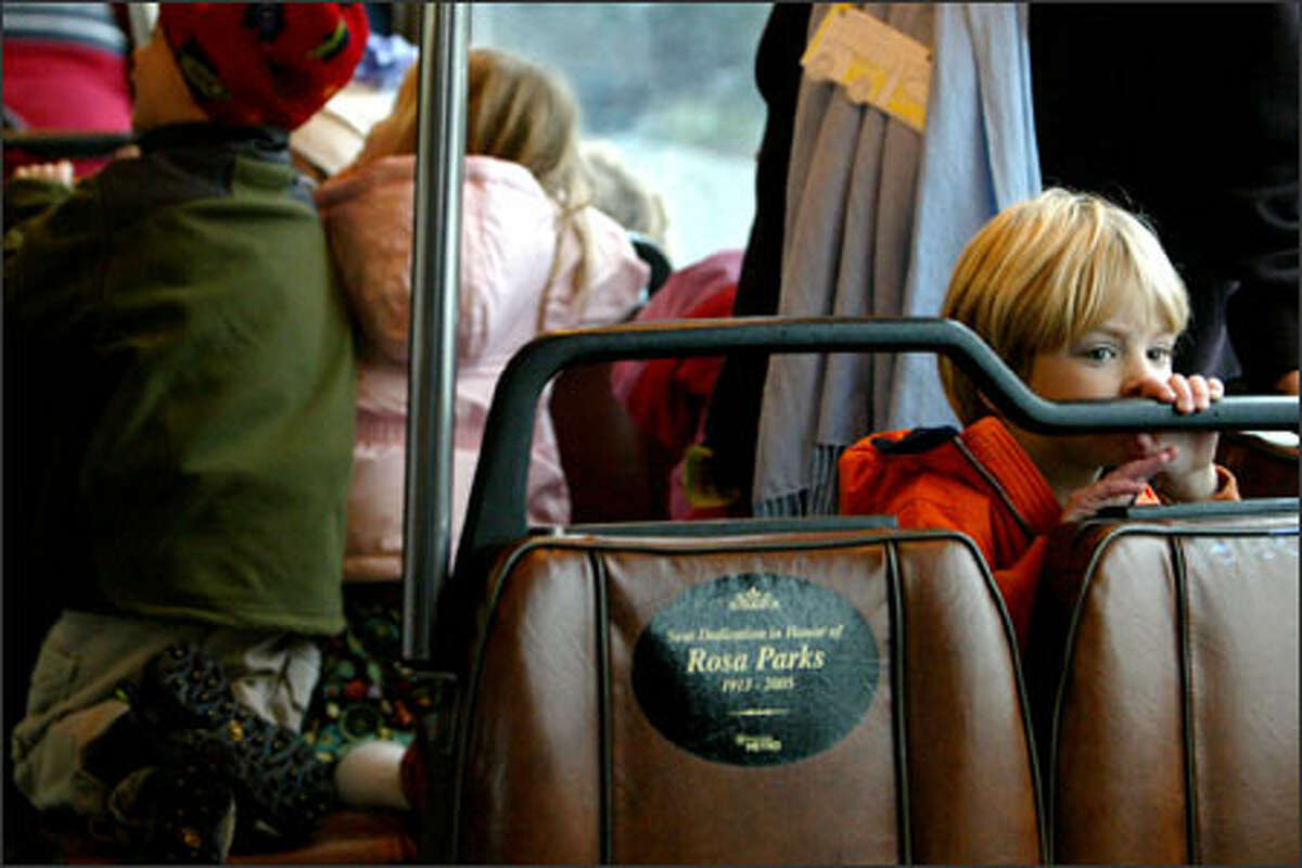 After a visit to the downtown Seattle library Thursday, Max Sorenson, right, a student at the St. Mark's Episcopal Cathedral preschool, takes the bus back to school along with other children from his class. Thursday was the 50th anniversary of the day that Rosa Parks refused to give up her seat to a white man on an Alabama bus, and the students, who have been learning about her life, rode the bus as part of their lesson. To honor Parks, Metro Transit has affixed a sign to a seat in every one of its buses.
