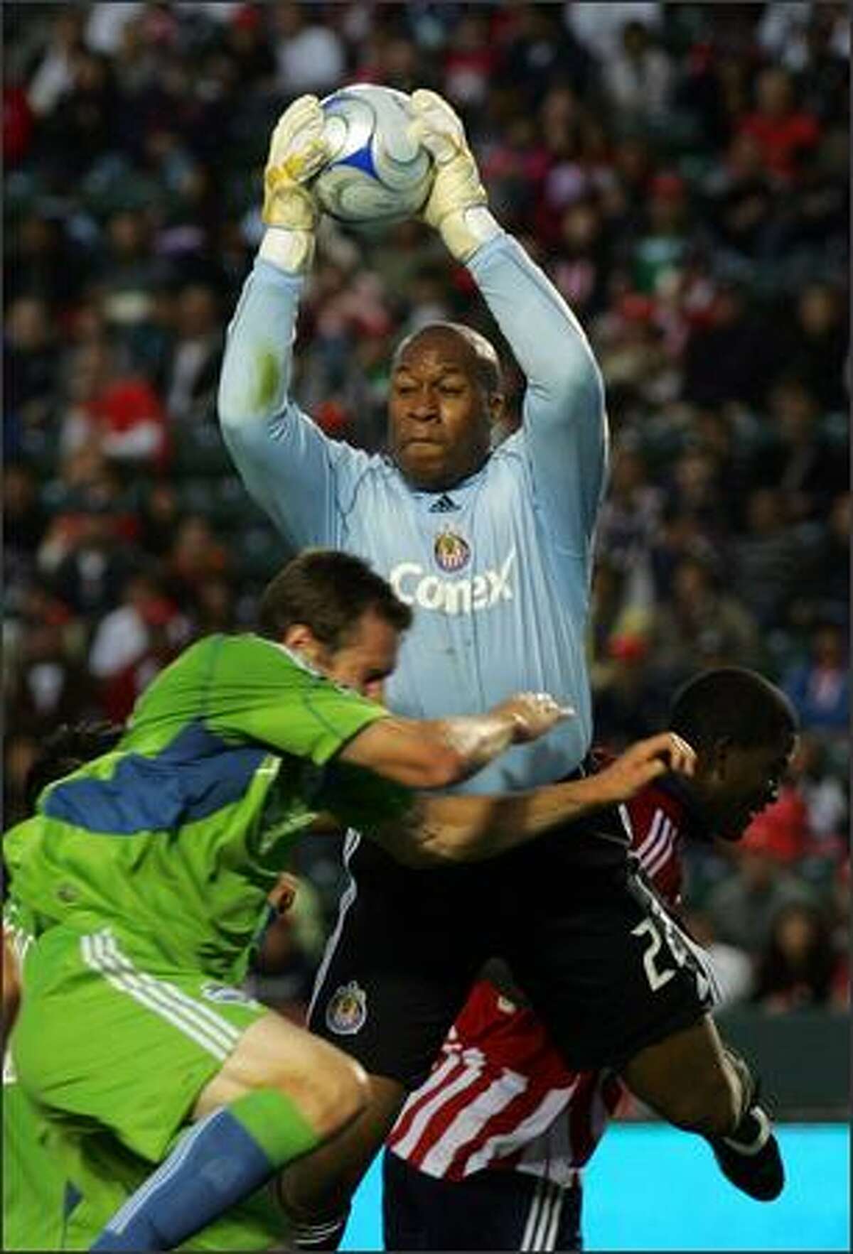 Goalkeeper Zach Thornton of Chivas USA makes a save in front of Nate Jaqua of Seattle Sounders FC on a corner kick in the first half.