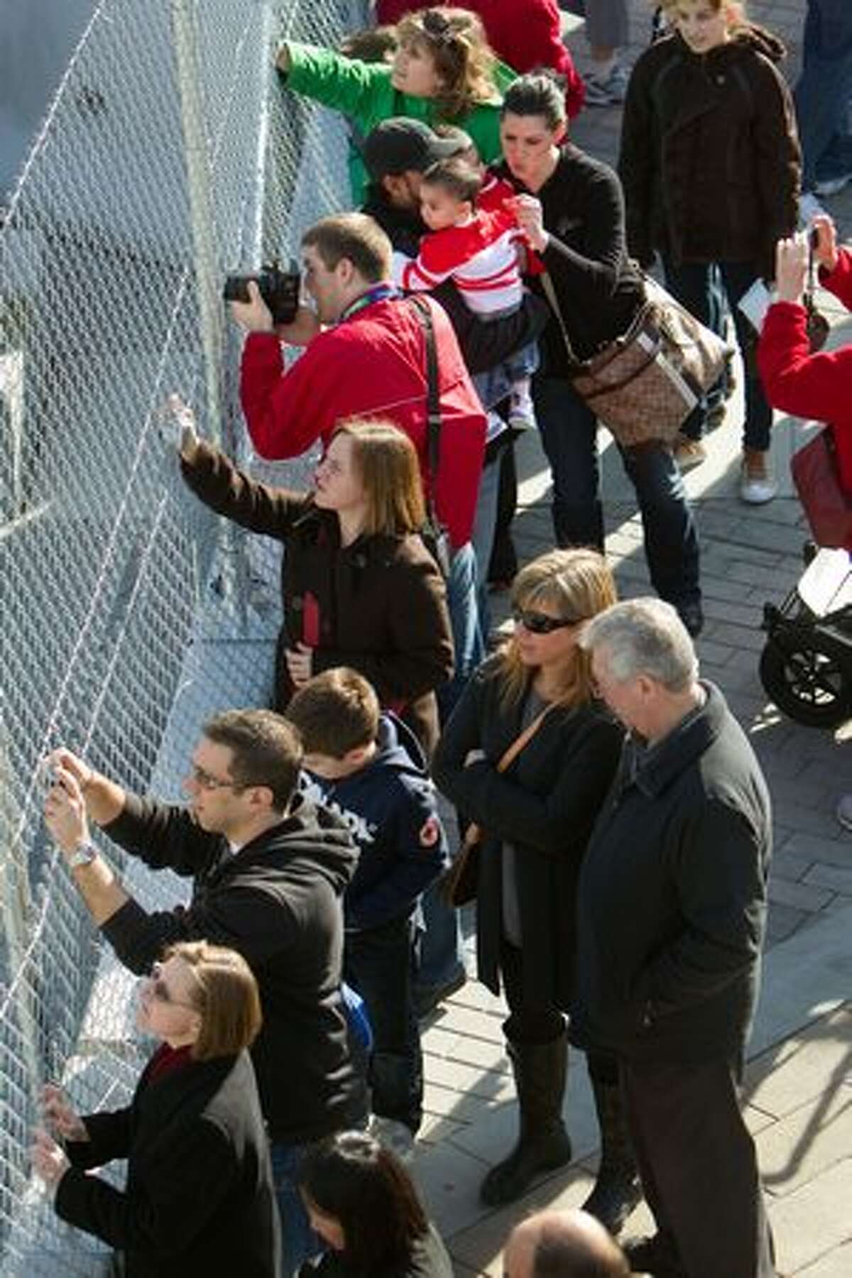Crowds press against a fence to see the Olympic cauldron in downtown Vancouver at the 2010 Winter Olympics on Wednesday, Feb. 17, 2010. Complaints about the inability to see the cauldron because of fencing prompted officials to open a viewing area and remove banners from the fences. The line for the viewing area was 45 minutes long. ( Smiley N. Pool / Houston Chronicle )