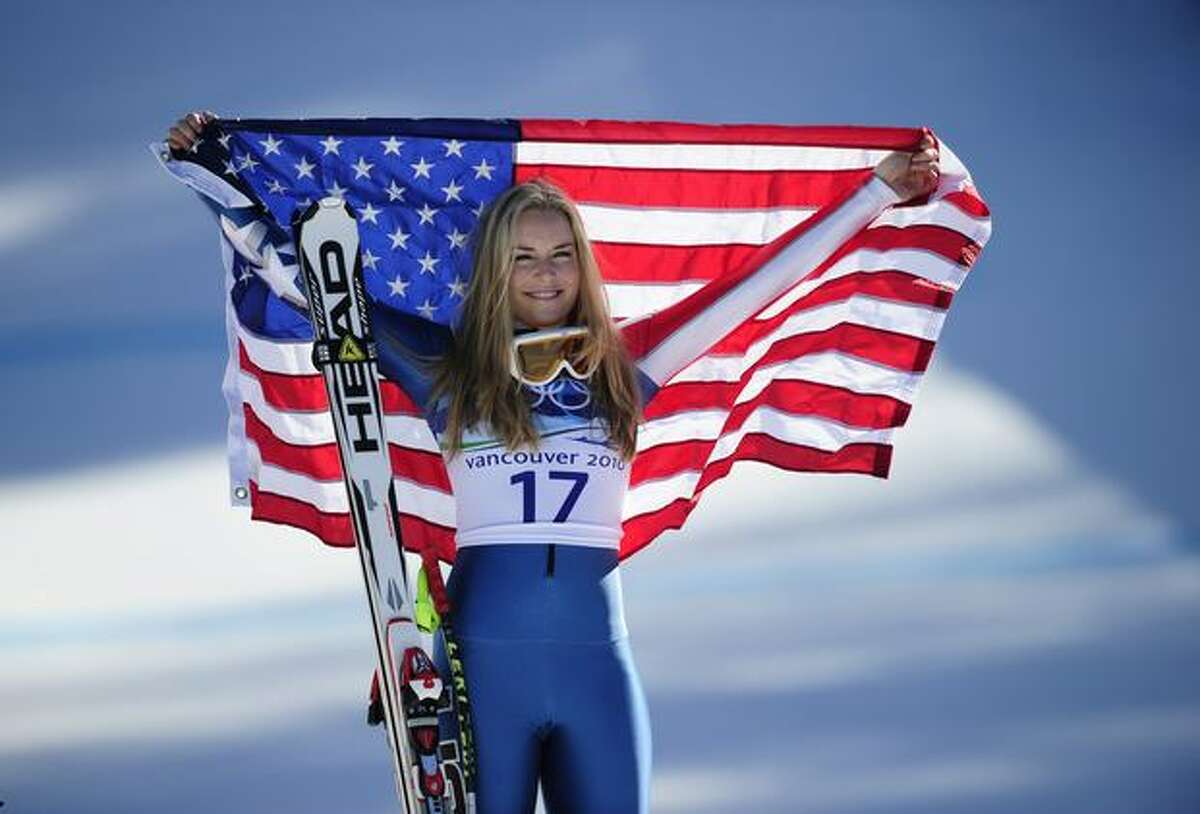 USA's bronze medalist Lindsey Vonn celebrates with her national flag on the podium during the flowers ceremony of the women's Super-G race of the Vancouver 2010 Winter Olympics at Whistler Creek side Alpine skiing venue on February 20, 2010.