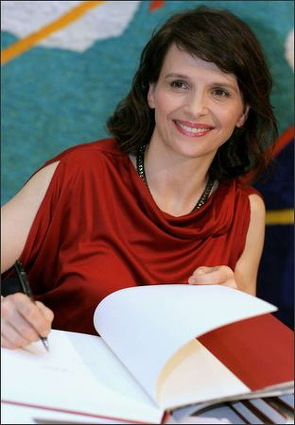 Actress Juliette Binoche signs autographs at the official launch of her latest book "Portraits - In Eyes" at the State Library of New South Wales in Sydney, Australia.