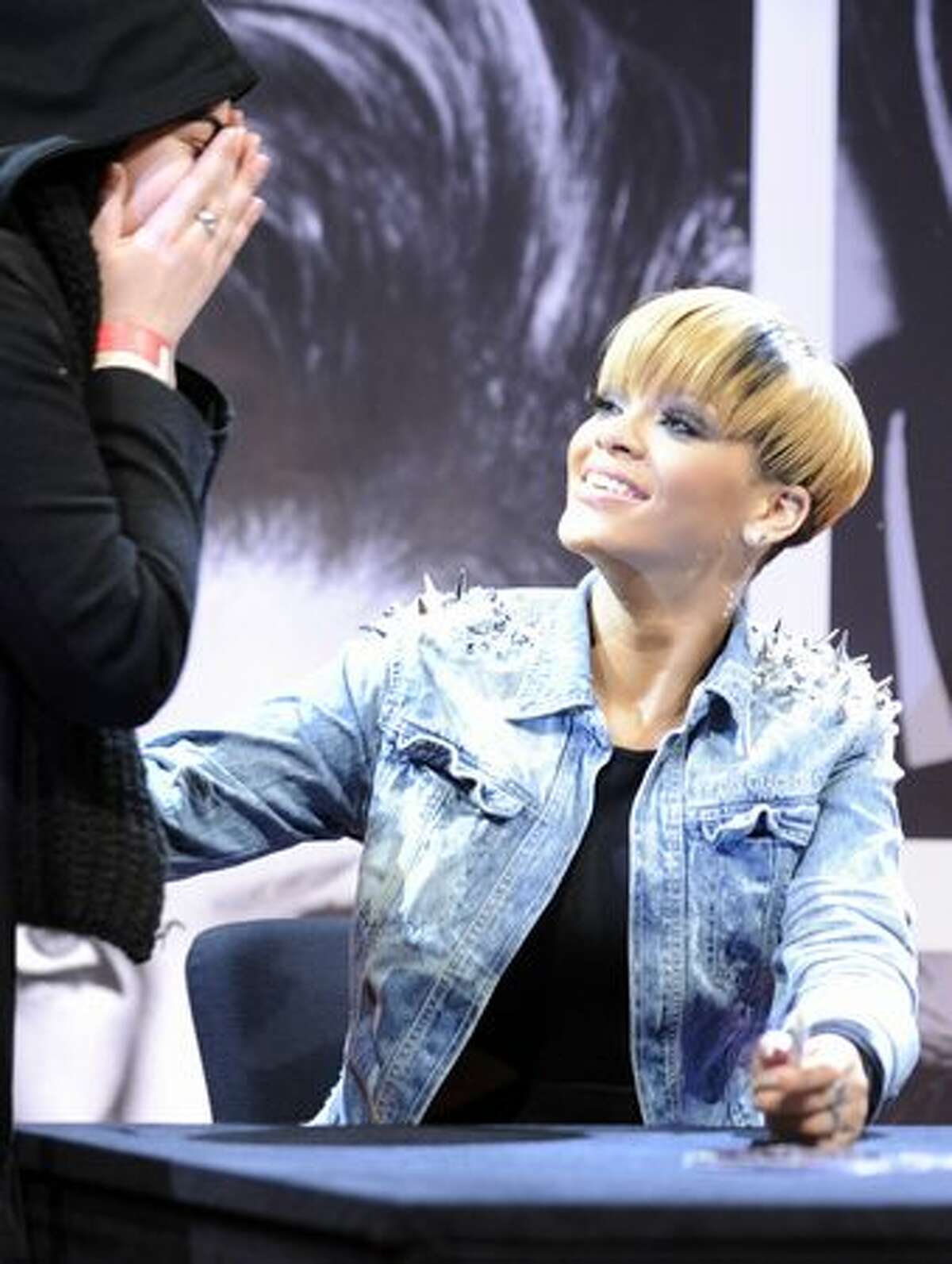 US singer Rihanna comforts a fan who cries as she receives an autograph at a shopping centre in Berlin.