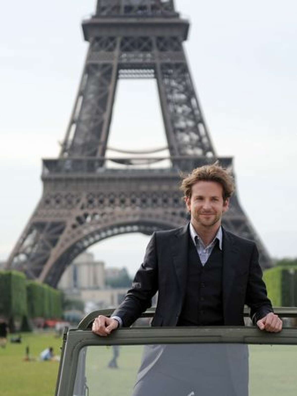Actor Bradley Cooper poses in a car in front of the Eiffel Tower during a photocall for the release in France of the A-team film.