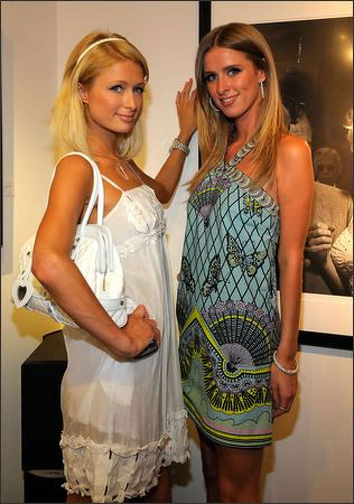 Socialites Paris Hilton (L) and Nicky Hilton attend the opening of "The Good Life: The Photographs Of Slim Aarons and Murray Garrett" at the Photographer's Gallery in Los Angeles, California.