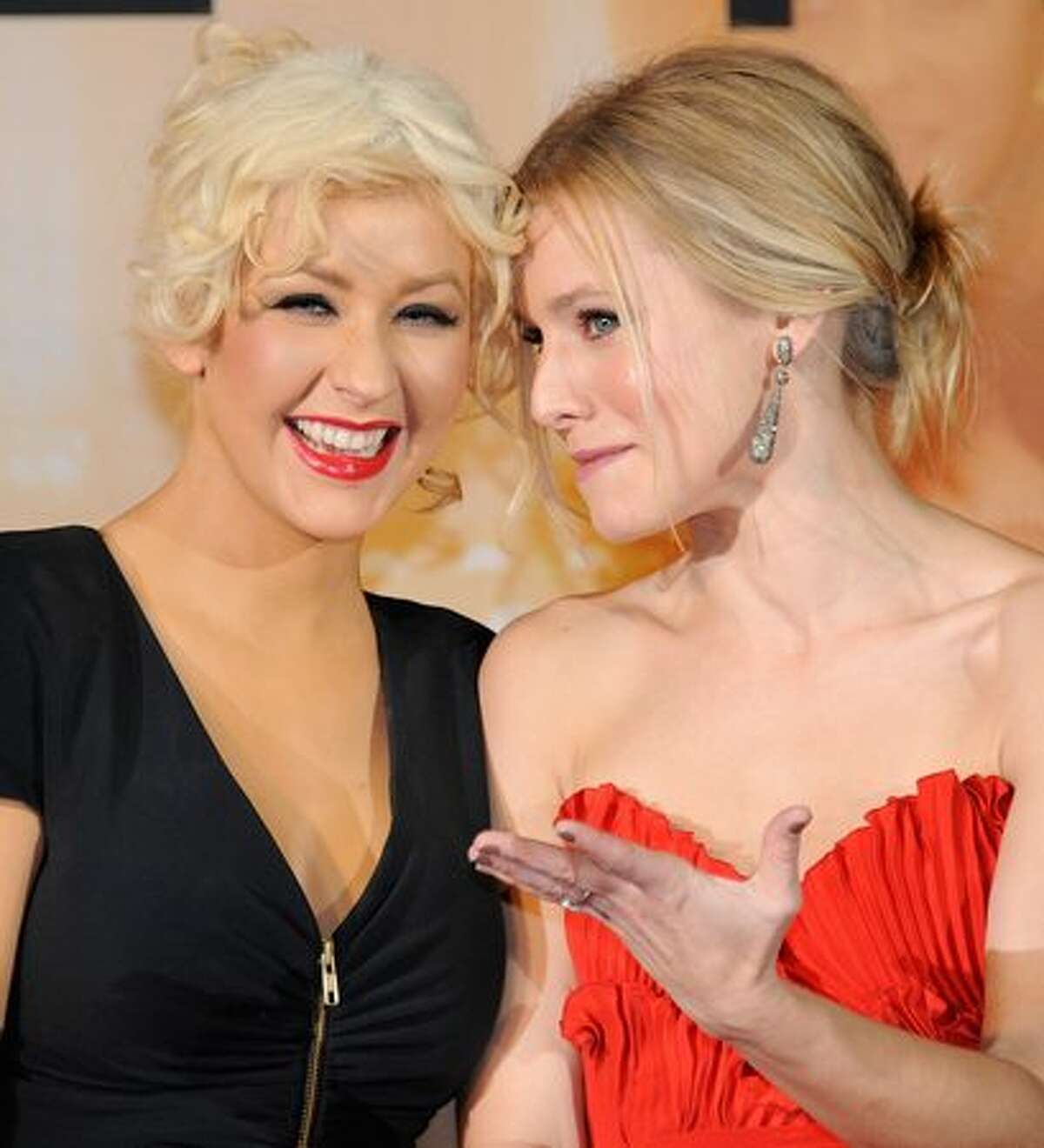 Actress Christina Aguilera (L) shares a light moment with Kristen Bell (R) during the Japan premier of their film "Burlesque" in Tokyo.
