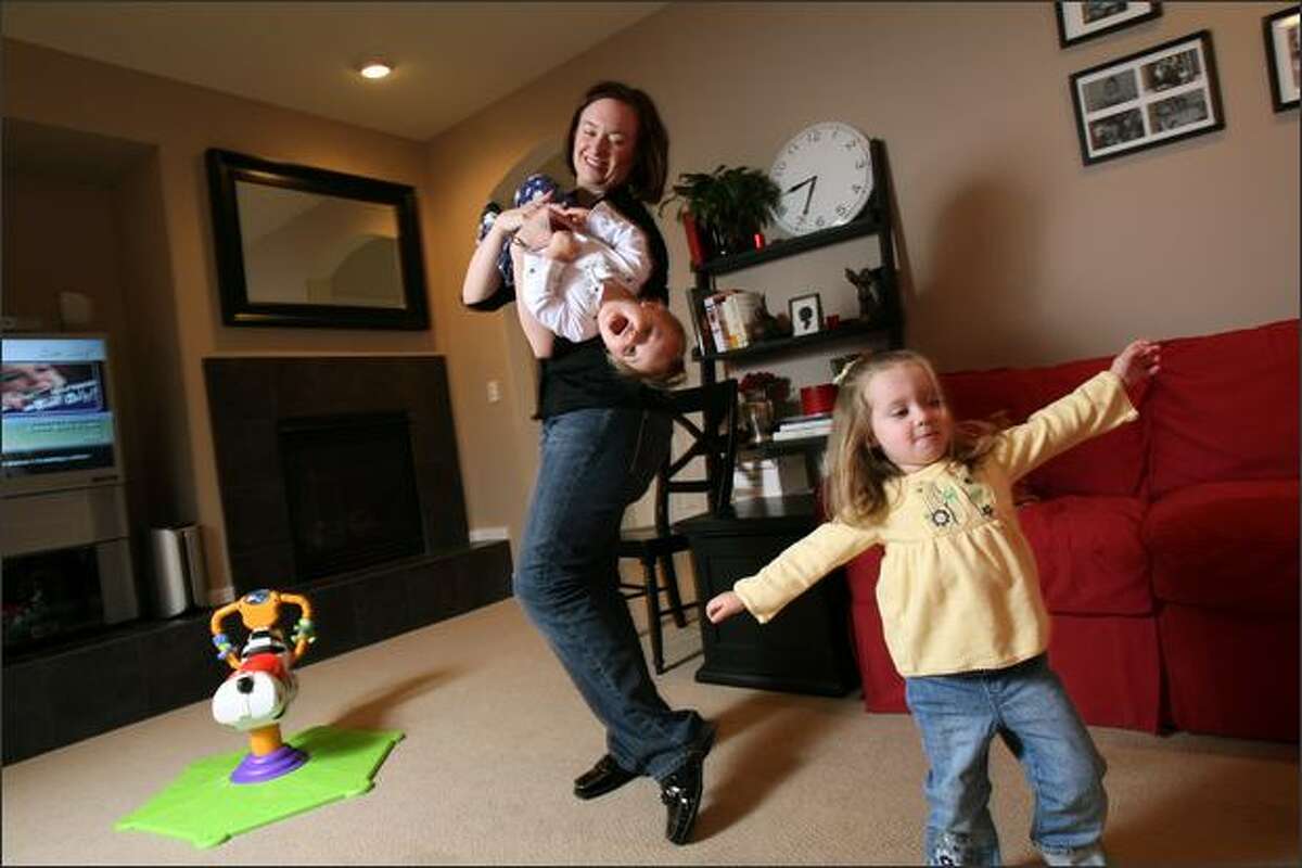 Karen Barker plays with her daughters, Katie, 2 (right) and Megan, 12 months, at their home in Woodinville, WA. She used a parent coach to help her manage all her responsibilities.