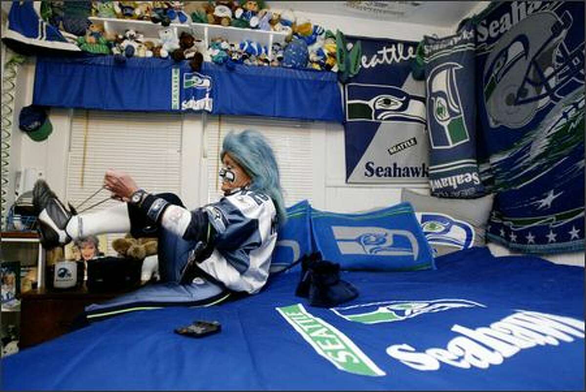 In the bedroom of her Auburn home, DeDe Schumaier, aka "Mrs. Seahawk," ties her shoes before heading to Seattle's Nov. 13, 2005, game against St. Louis.