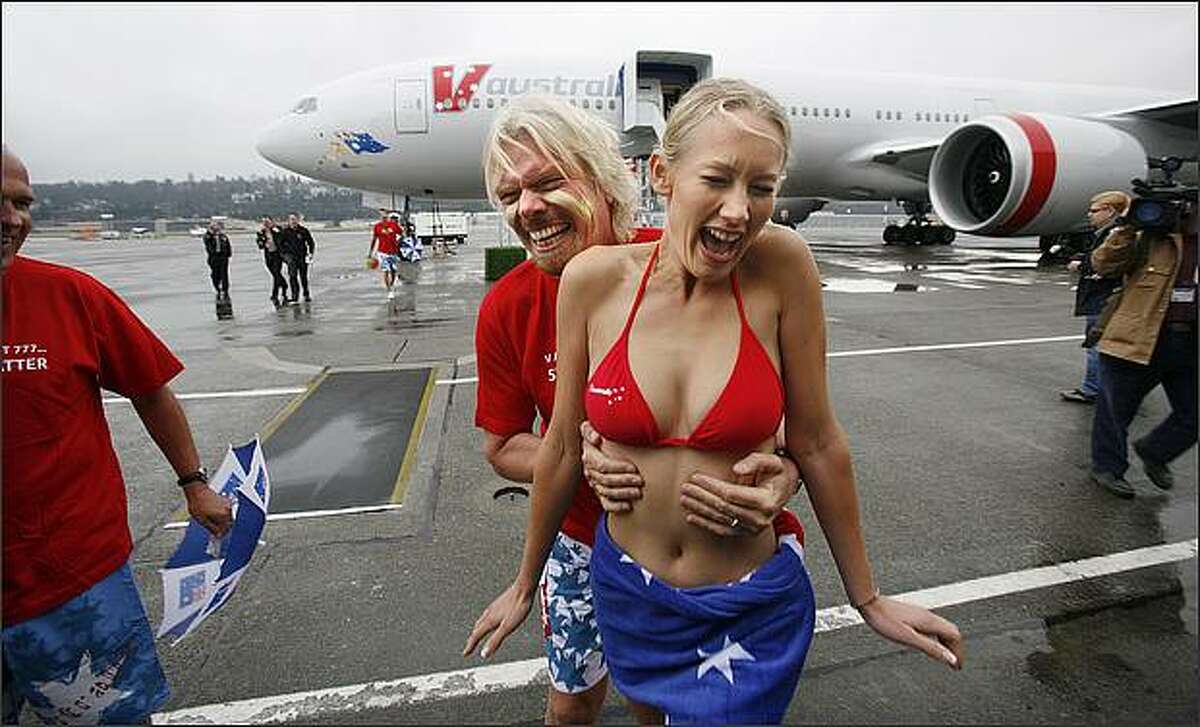 Sir Richard Branson, co-founder of the new airline V Australia, surprises flight attendant Catherine Blackbee during a delivery ceremony for the airline's 777-300ER at Boeing Field.