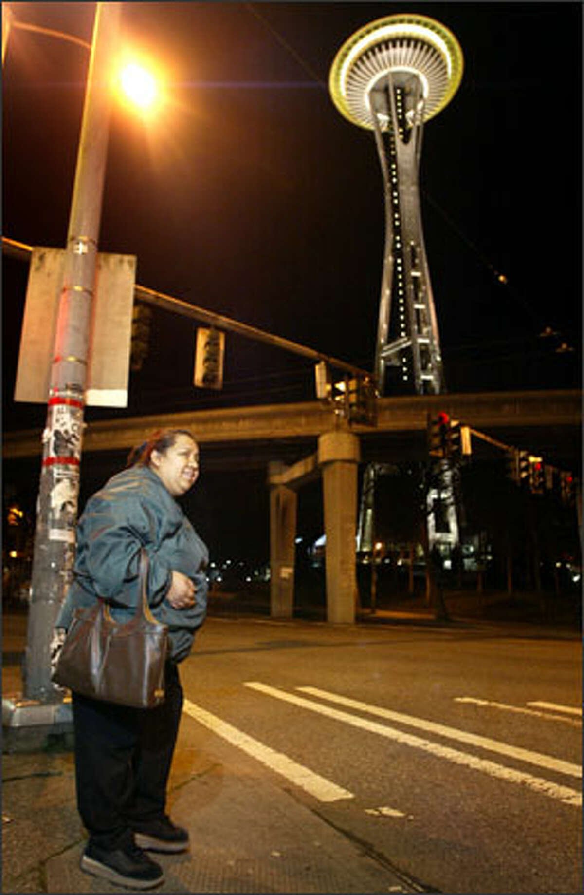 Narciza Pineda, 42, prepares to cross Broad Street on her way to her job as a janitor at the Space Needle, where she earns $10.75 an hour -- more than minimum wage, but barely enough for her family to live on.
