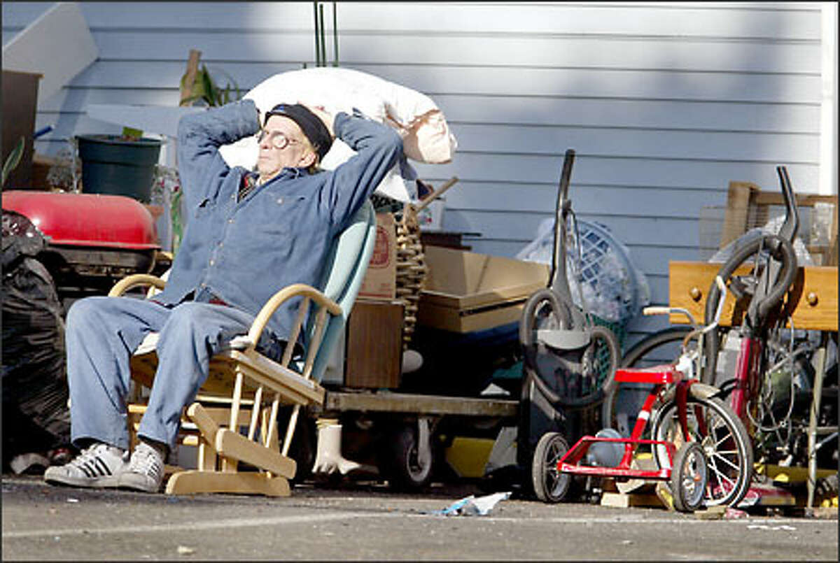After eviction from the Juanita Apartments in Burien, Jeff Hoskinson waits with his belongings outside the apartment building.