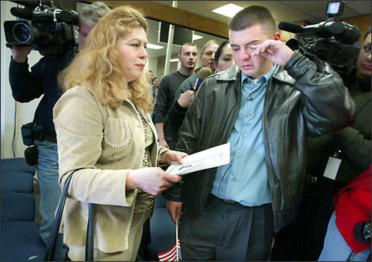 Juan Escalante, with his mother, Silvia, is overcome with emotion while taking his oath to become a U.S. citizen in a ceremony Wednesday in Seattle.