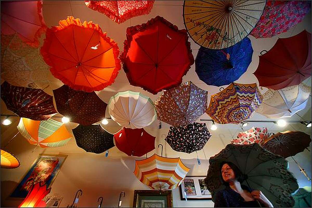 Customer Cheryl Wilson checks out one of the umbrellas at Bella Umbrella. The small shop rents and sells vintage and antique umbrellas.