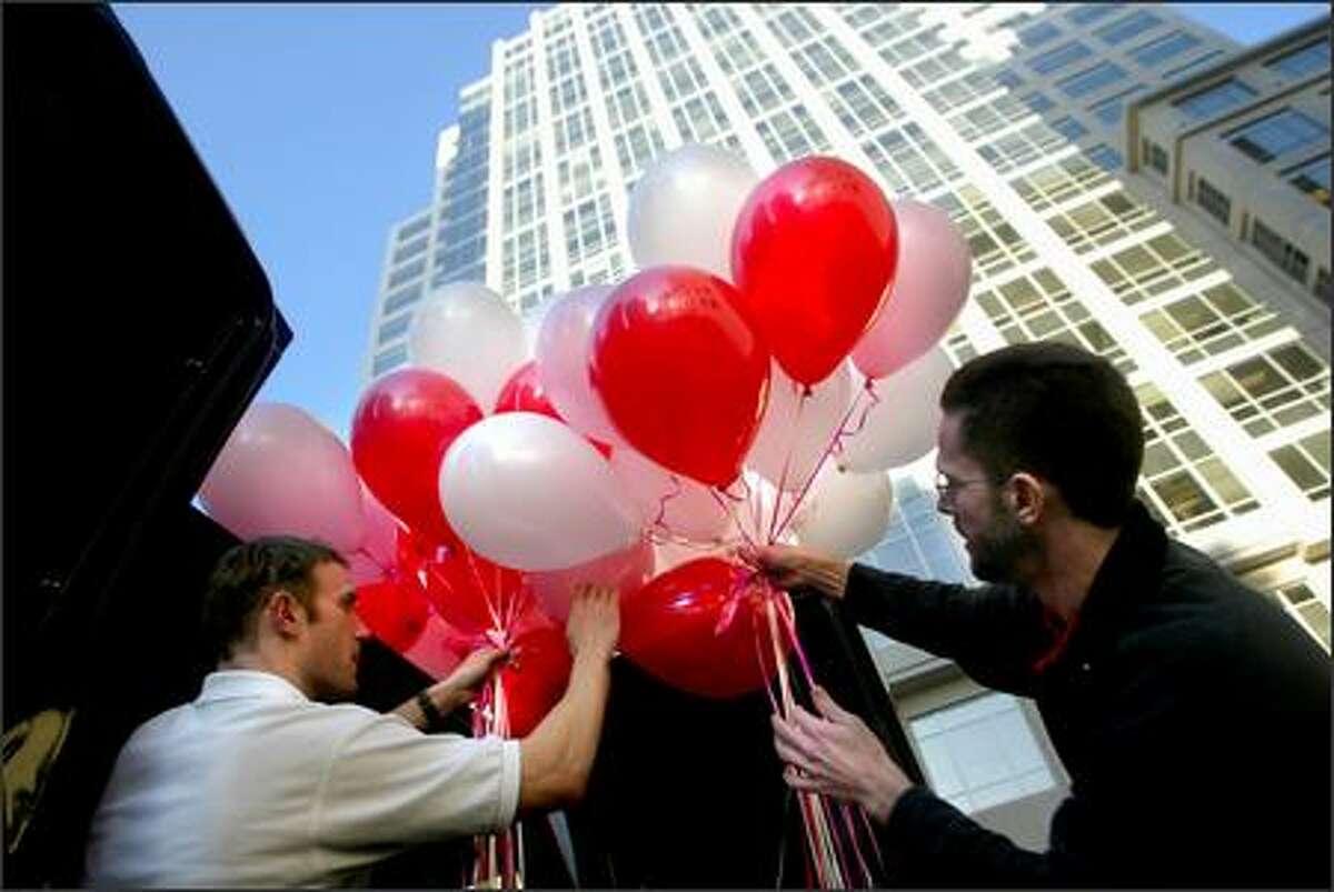 Gerry Tonsor, left, and Craig Mathews from The Red Balloon Co. load a van full of balloons in Seattle on Monday. The company, which specializes primarily in balloon delivery and decorating, also sells gifts, cards, and retro toys. Manager Cameron Vail said business before this Valentine’s Day has been "extremely busy."