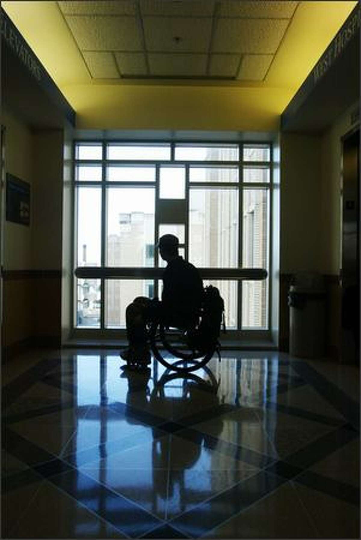 Brian Chaffin, 25, who broke his back three years ago and spent months at Harborview, pauses in a hallway. During his recovery, natural light and skyscapes were solace for Chaffin.