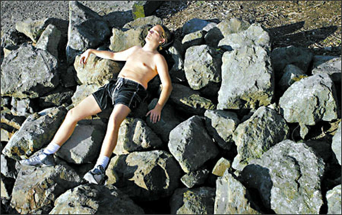 With temperatures climbing into the lower 60s Sunday in Seattle, Colin Yokum found the perfect combination of rocks for a siesta at Myrtle Edwards Park. He said his bed of boulders was more comfortable than it looked.