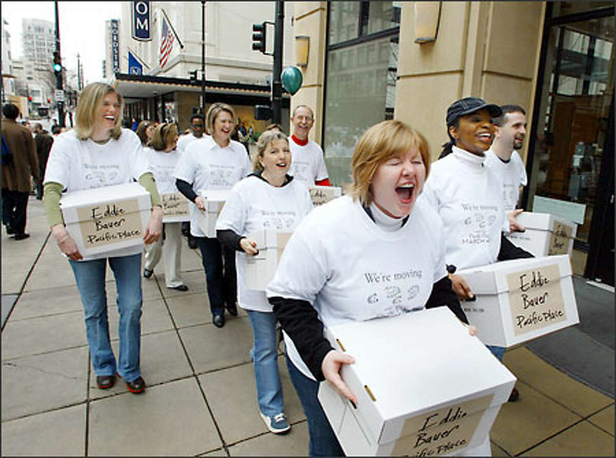 Deborah Anderson, front, leads more than 350 Eddie Bauer Inc. employees as they move merchandise and supplies Thursday from the company's downtown Seattle flagship store to its new location in Pacific Place. The new, 7,500-square-foot store will open Thursday. Brooks Brothers will begin construction next week in the old Eddie Bauer space for a new Northwest flagship store.
