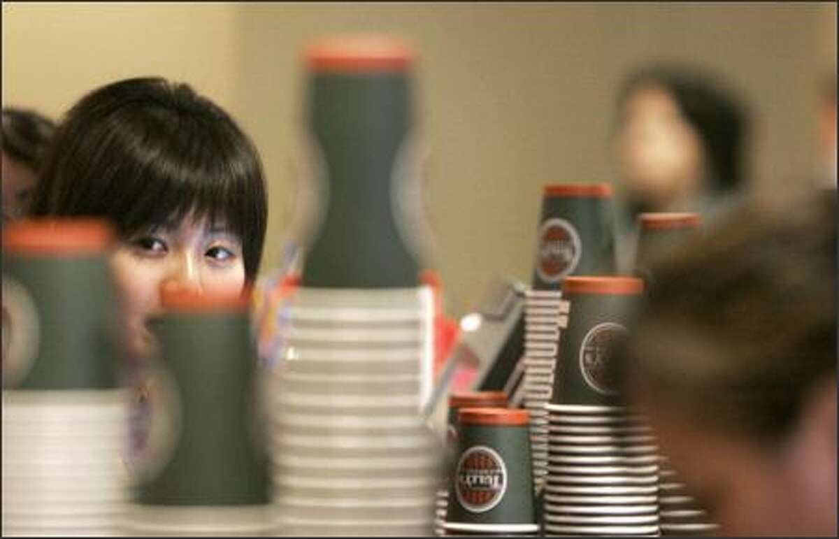 UW freshman Rosemary Gong, 19, sells coffee on campus Wednesday. The university goes through about 5,000 paper cups a day, and a "Sustainability Is Sexy" campaign has been launched asking students to use their own coffee cups instead of paper cups.