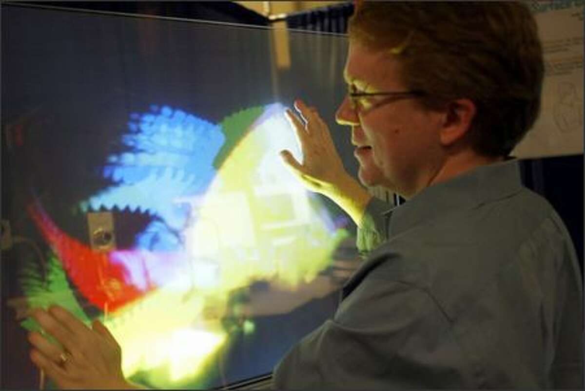 Microsoft researcher Andy Wilson uses his TouchLight project at the annual Microsoft Research TechFest at the campus in Redmond yesterday. His project is an example of efforts by researchers to use different surfaces as alternative computer interfaces. About 150 projects were on display.