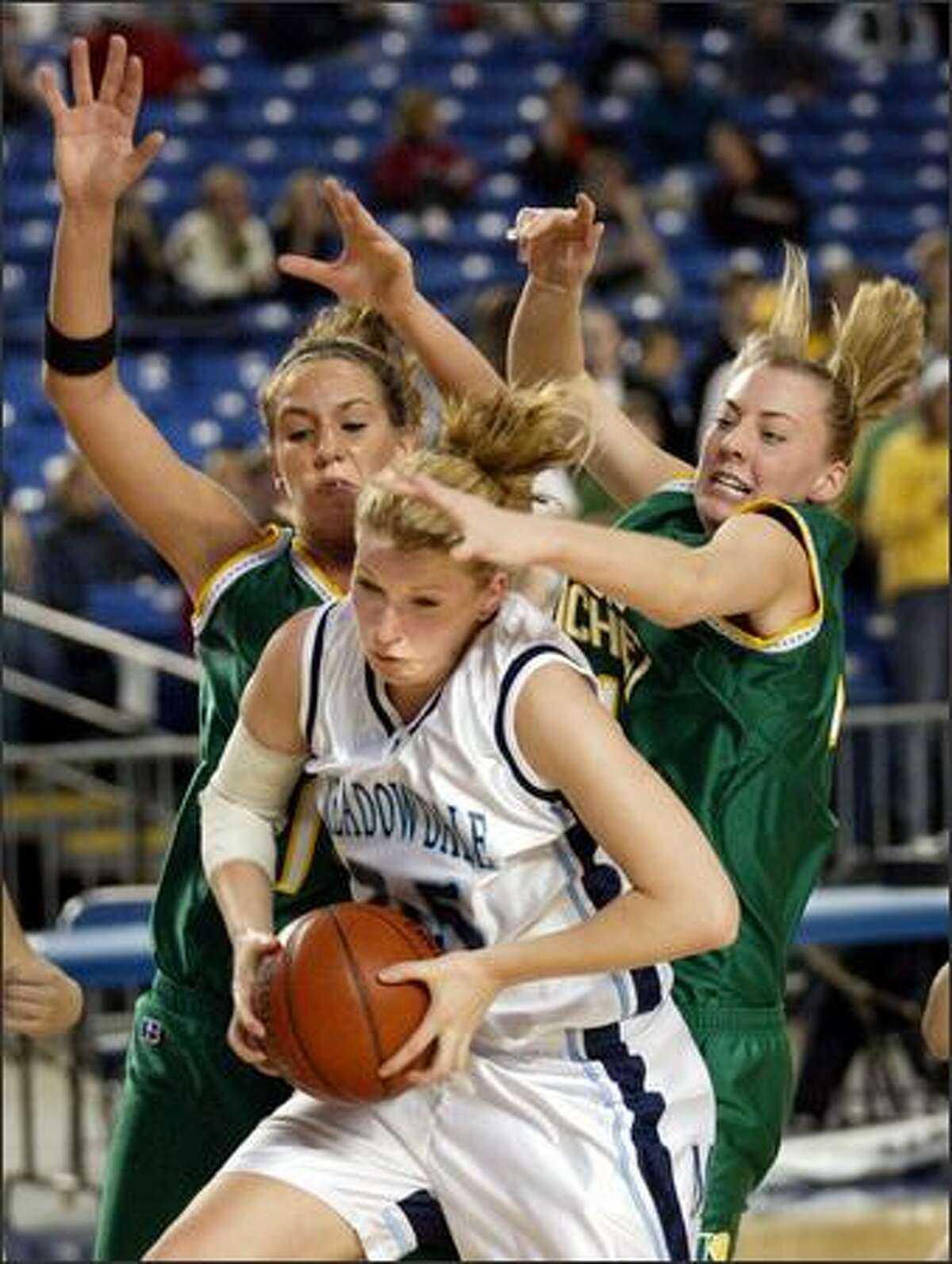 Bishop Blanchet players Krista Lersch (left) and Erika Pettersen trap Meadowdale senior Quinn Brewe, who had nine points and eight rebounds.