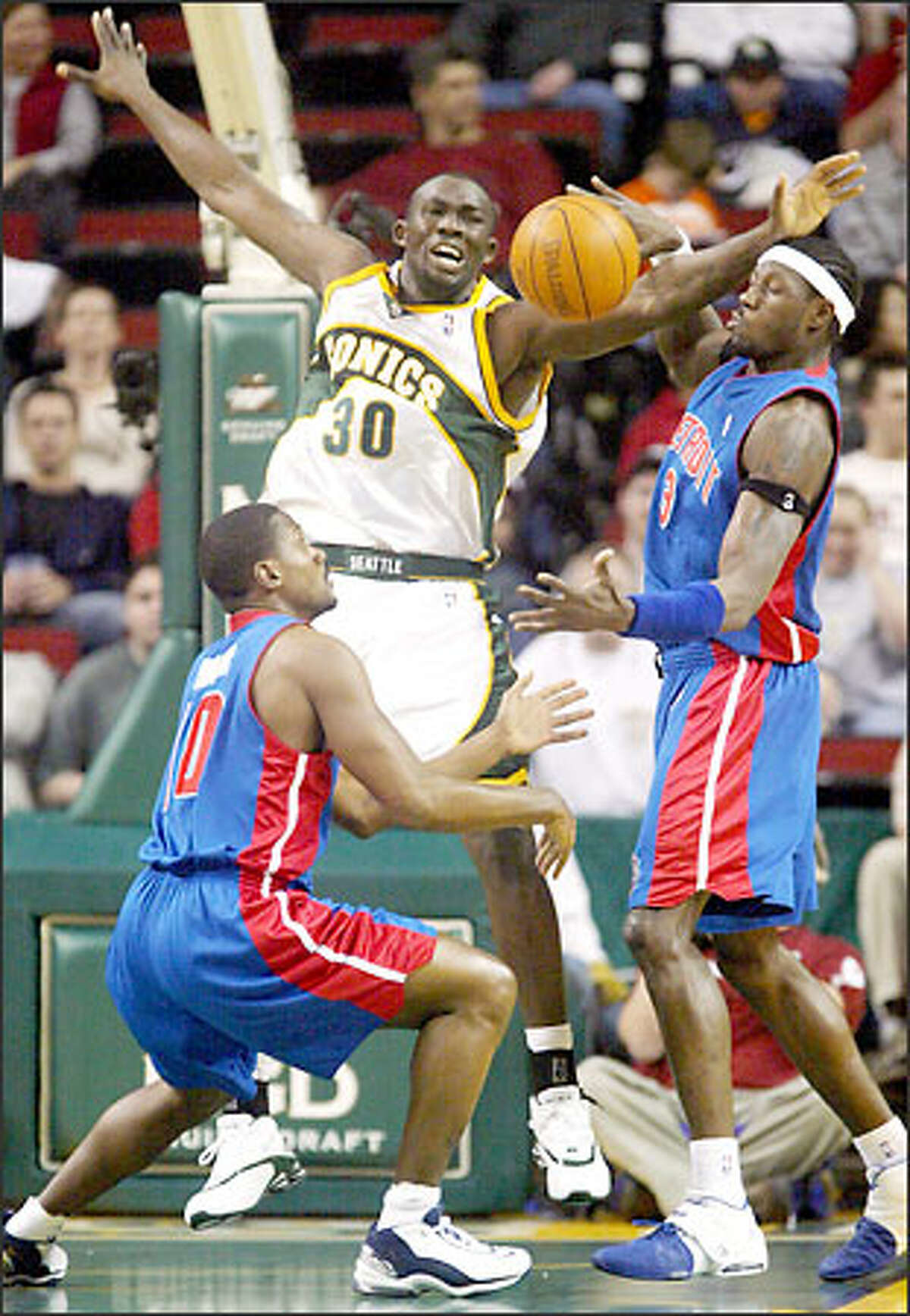 Detroit's Lindsey Hunter, left, and Ben Wallace, right, scrap with Reggie Evans of the Sonics for the ball.