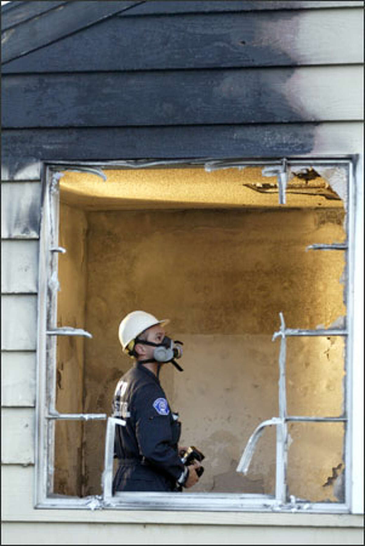 Fire investigator Joe Rexach inspects damage to a Kirkland church owned by the Gospel Hall Foundation.
