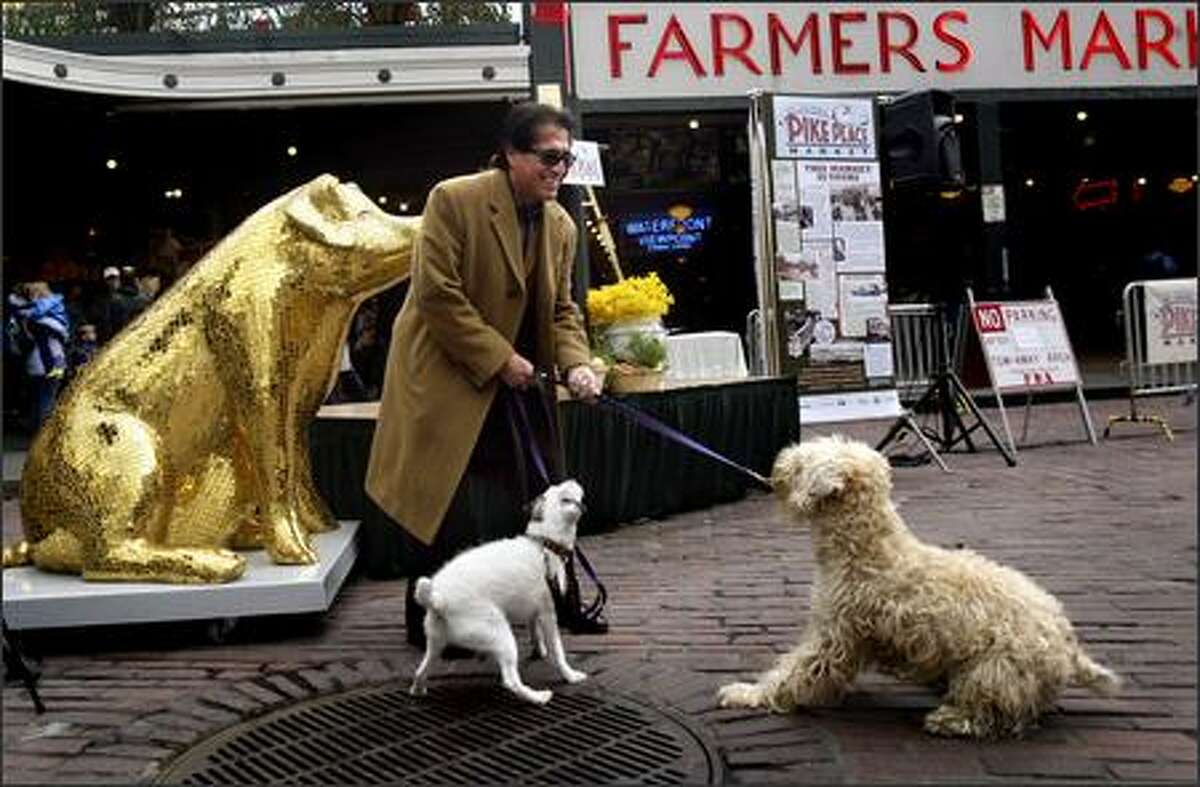Gil Trujillo tries to convince Norton, left, and Chumley to pose for a picture with him in front of Lucky, a pig decorated by artist Rebecca DeVere for Washington Mutual, in front of Pike Place Market Tuesday. Lucky was on hand to help kick off of the Centennial Celebration of the Pike Place Market, which featured speeches by market and city officials, a musical performance, dancing fish and free cake for the public.