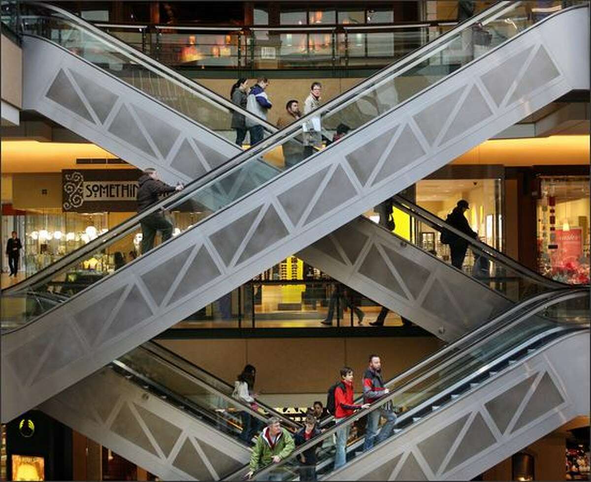 Shoppers and diners ride the escalators at Pacific Place shopping center in downtown Seattle.