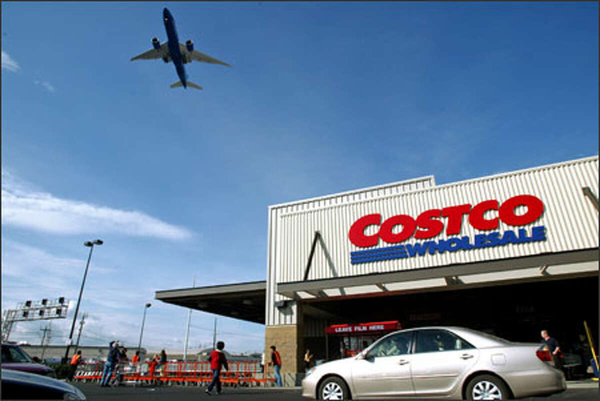 A jet soars overhead on opening day at Costco Wholesale Corp.'s new South Seattle store. The new faux warehouse replaces the company's very first store, built in an actual renovated warehouse.