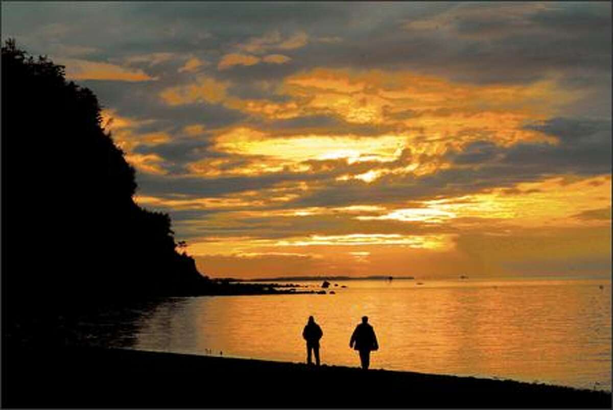 Nevada residents Giselle Tenhompel and Roger Farquhar take in a sunset along the edge of the Strait of Juan de Fuca at Fort Worden State Park.