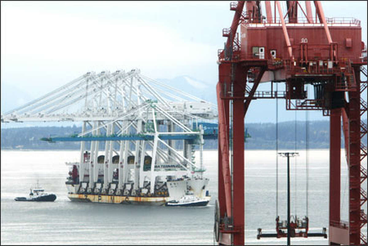 A ship arrives from Shanghai at the Port of Seattle on Sunday with four huge cranes, each weighing 1,200 tons and standing 385 tall. They were bought by SSA Marine, a stevedoring and terminal operations company, to replace aging ones owned by the port.